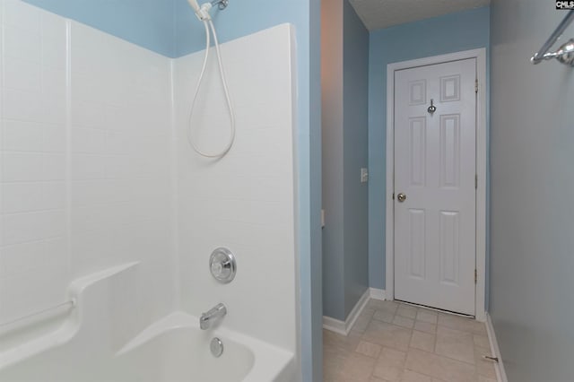 bathroom with a textured ceiling and shower / bathtub combination