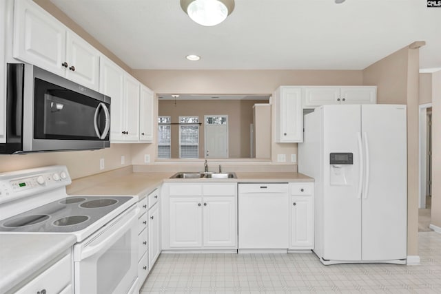 kitchen featuring white cabinetry, sink, and white appliances