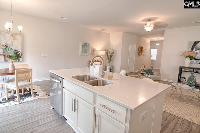 kitchen with white cabinets, sink, light hardwood / wood-style flooring, stainless steel dishwasher, and an island with sink