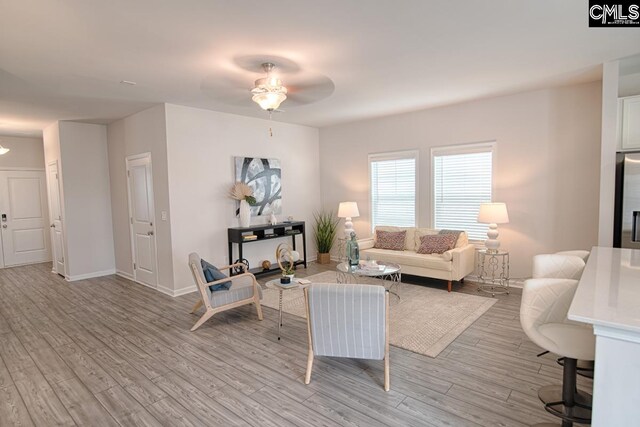 living room with ceiling fan and light hardwood / wood-style flooring