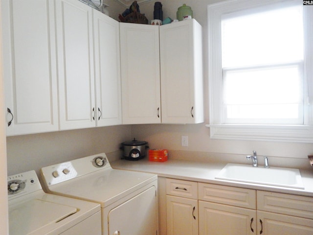 washroom featuring cabinets, independent washer and dryer, and sink