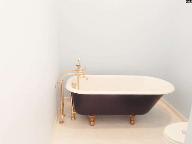 bathroom featuring a bathing tub, tile patterned flooring, and toilet