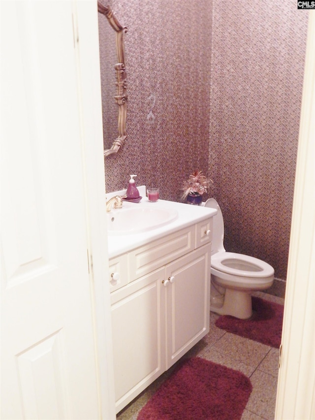 bathroom featuring tile patterned floors, vanity, and toilet