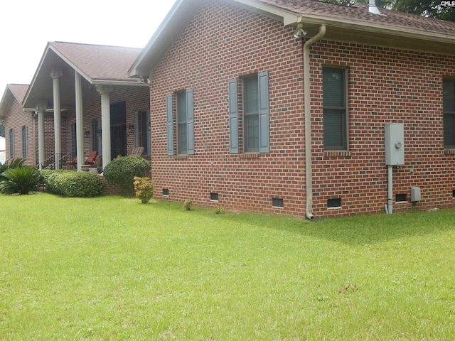 view of side of home with a yard