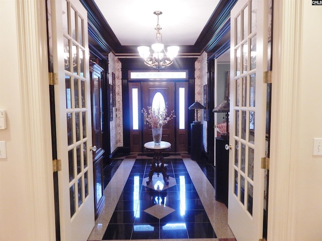 foyer featuring french doors, an inviting chandelier, and ornamental molding