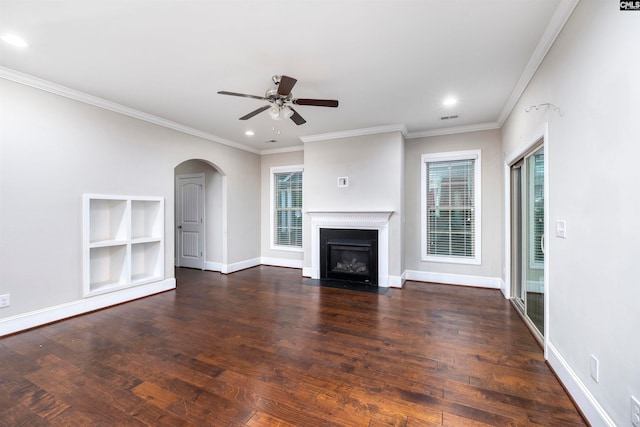 unfurnished living room with plenty of natural light, ornamental molding, and dark wood-type flooring