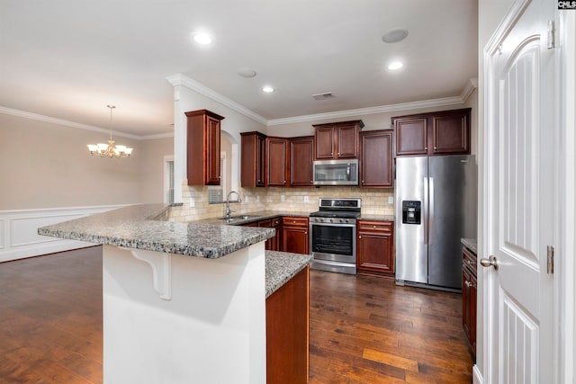 kitchen with kitchen peninsula, stainless steel appliances, sink, dark hardwood / wood-style floors, and hanging light fixtures