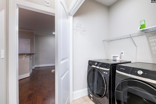 washroom with separate washer and dryer, crown molding, and wood-type flooring