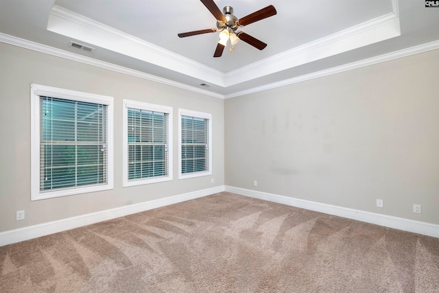 carpeted spare room featuring ceiling fan, a raised ceiling, and crown molding