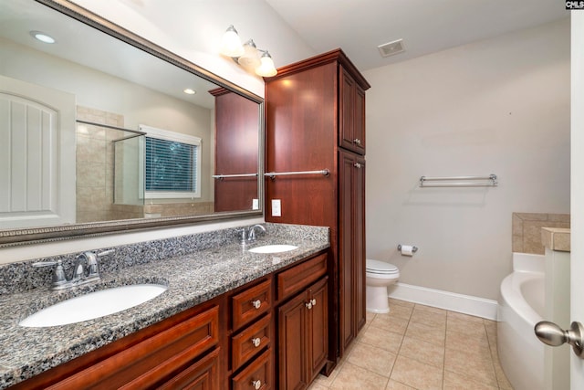 bathroom featuring vanity, tile patterned flooring, a bathtub, and toilet