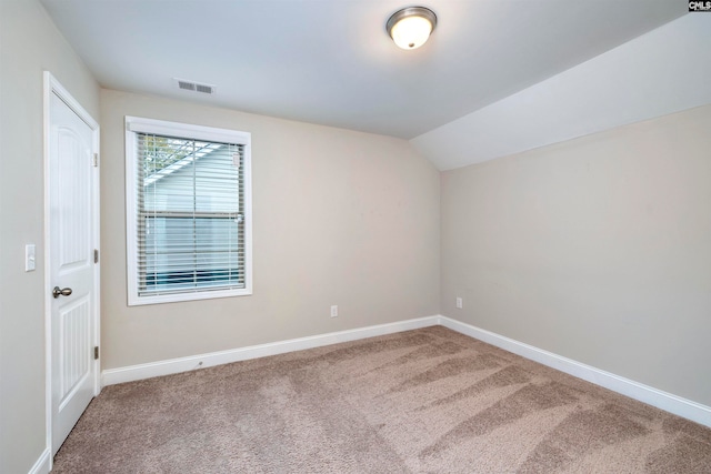 empty room featuring carpet floors and lofted ceiling