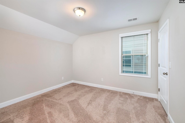 carpeted empty room featuring lofted ceiling