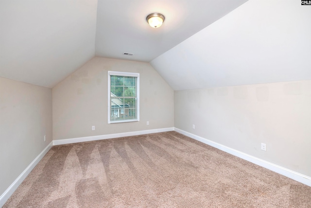 additional living space with carpet flooring and vaulted ceiling