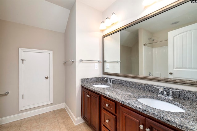 bathroom featuring tile patterned floors, vanity, and lofted ceiling