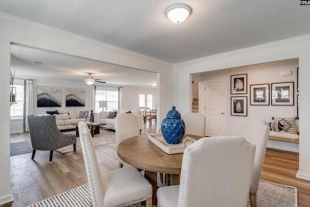 dining area featuring light hardwood / wood-style flooring, ceiling fan, and crown molding