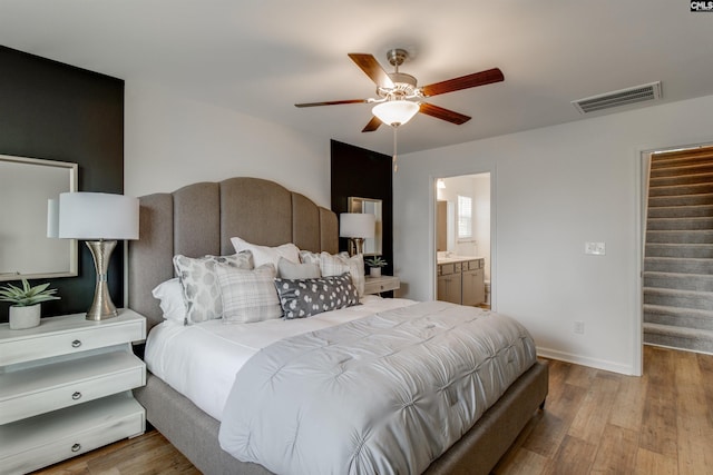 bedroom featuring ensuite bathroom, light hardwood / wood-style flooring, and ceiling fan