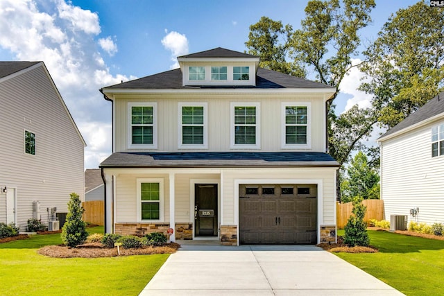 view of front of house with a front yard, a garage, and central AC unit