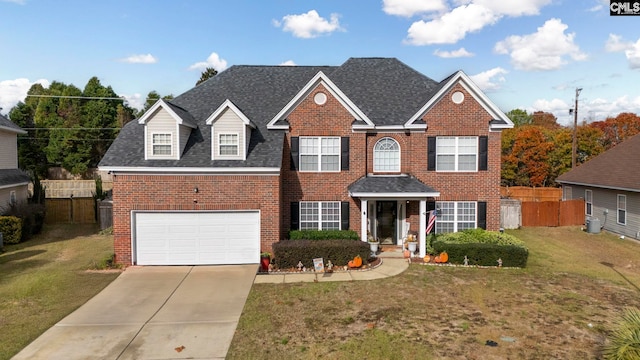 view of front of house featuring central AC unit, a garage, and a front lawn