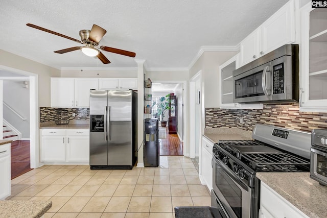 kitchen featuring white cabinetry, crown molding, light tile patterned floors, and stainless steel appliances