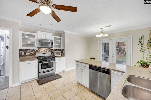 kitchen with stainless steel appliances, sink, light tile patterned floors, decorative light fixtures, and white cabinets