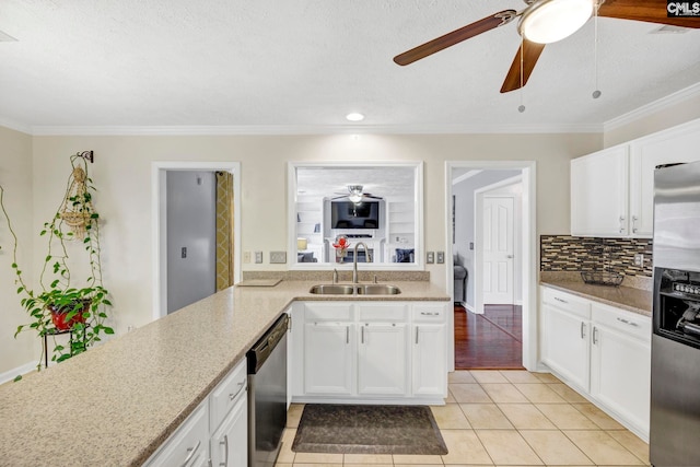 kitchen with sink, light tile patterned floors, crown molding, white cabinets, and appliances with stainless steel finishes