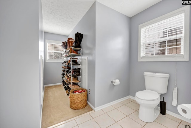 bathroom featuring tile patterned floors, a textured ceiling, and toilet