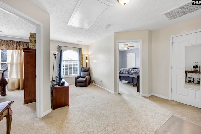 interior space with a textured ceiling, ceiling fan, and light carpet