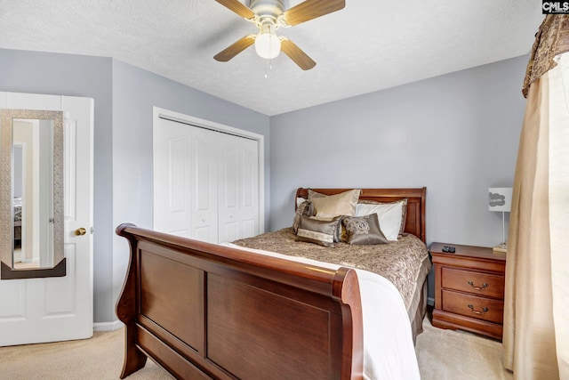 carpeted bedroom featuring a textured ceiling, a closet, and ceiling fan