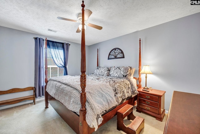 carpeted bedroom featuring a textured ceiling and ceiling fan