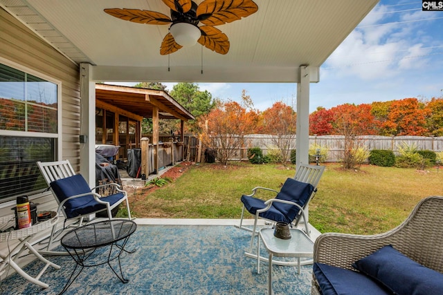 view of patio / terrace with ceiling fan and a bar