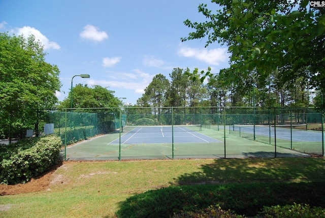 view of sport court with a lawn