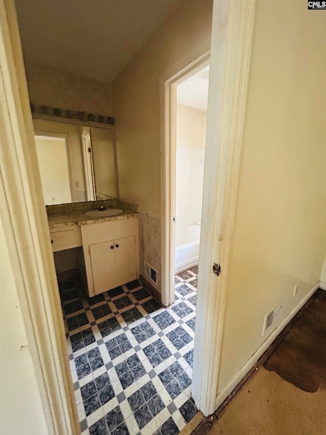 bathroom with vanity and a tub