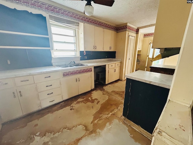 kitchen featuring a textured ceiling, white cabinetry, ceiling fan, and sink