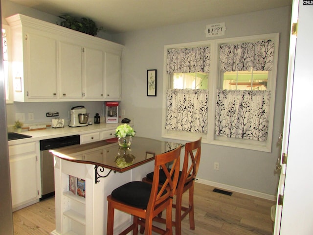 kitchen featuring light hardwood / wood-style flooring, white cabinets, and stainless steel dishwasher