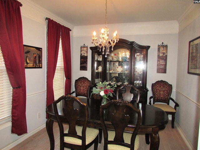 dining space with a notable chandelier, ornamental molding, and light hardwood / wood-style flooring