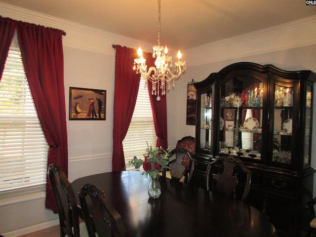 dining room with crown molding and a chandelier