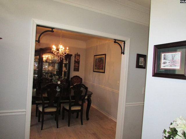 dining room featuring a chandelier, wood-type flooring, and ornamental molding