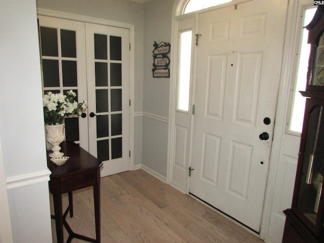 foyer entrance featuring hardwood / wood-style floors, french doors, and a healthy amount of sunlight