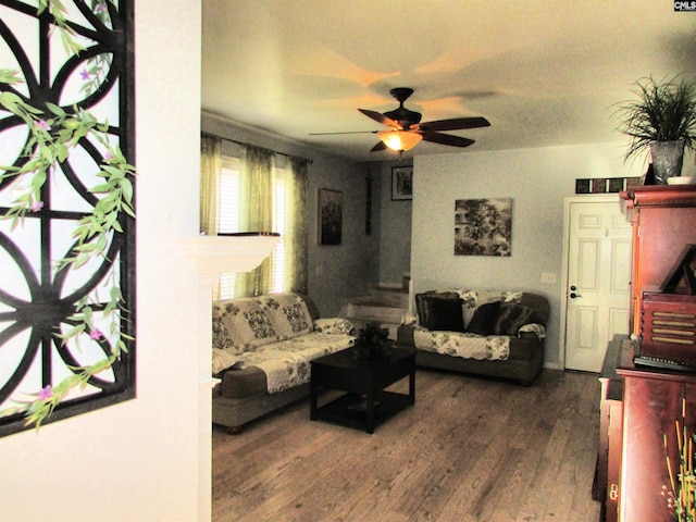 living room featuring ceiling fan and dark wood-type flooring