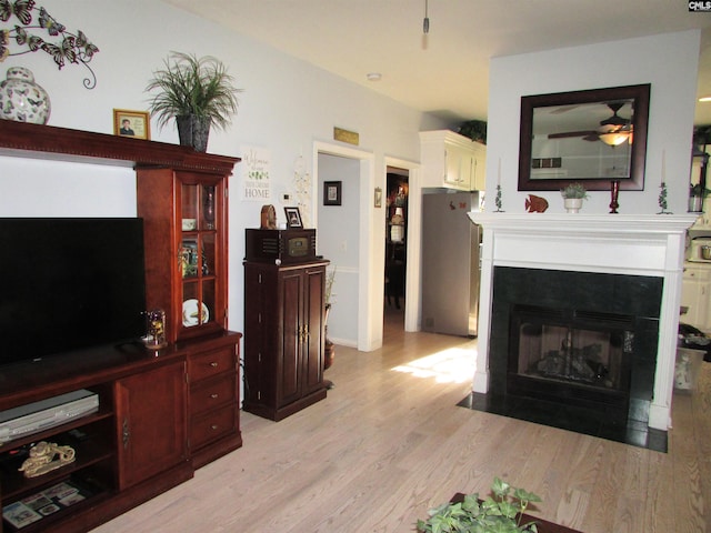 living room with light wood-type flooring and ceiling fan