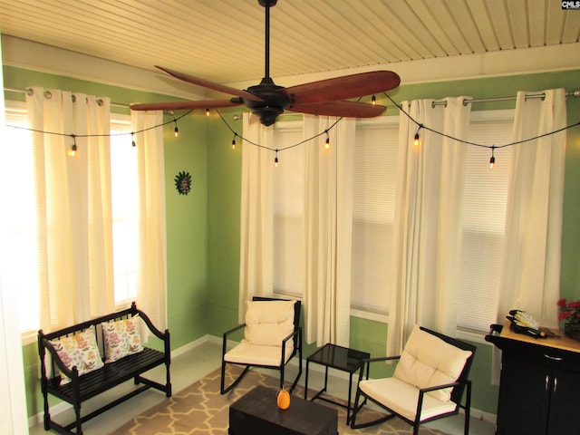 living area featuring ceiling fan and wooden ceiling