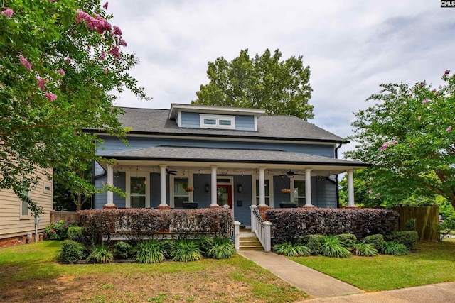 view of front of house featuring covered porch, ceiling fan, and a front yard