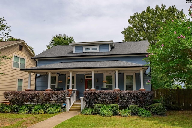 view of front of home featuring ceiling fan, covered porch, and a front yard