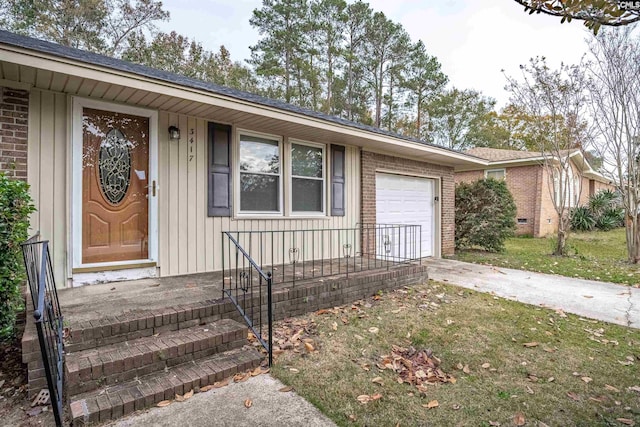 doorway to property featuring a garage and a lawn