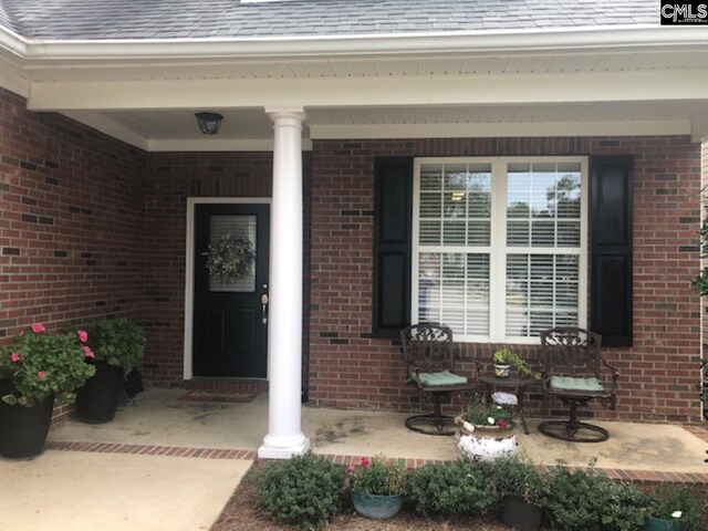 346 Arbor Oaks Ln, Irmo, SC 29063 - view of exterior entry featuring covered porch, brick siding, and roof with shingles