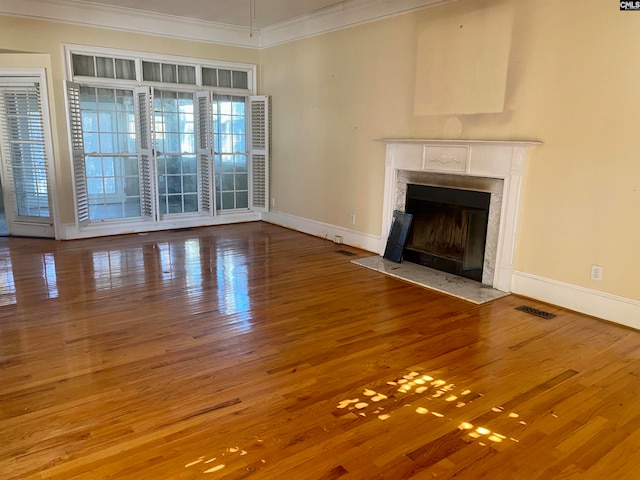 unfurnished living room with hardwood / wood-style flooring and ornamental molding