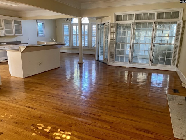 105 Overbranch Dr, Columbia, SC 29223 - kitchen with ornamental molding, wood finished floors, white cabinets, a center island with sink, and decorative columns