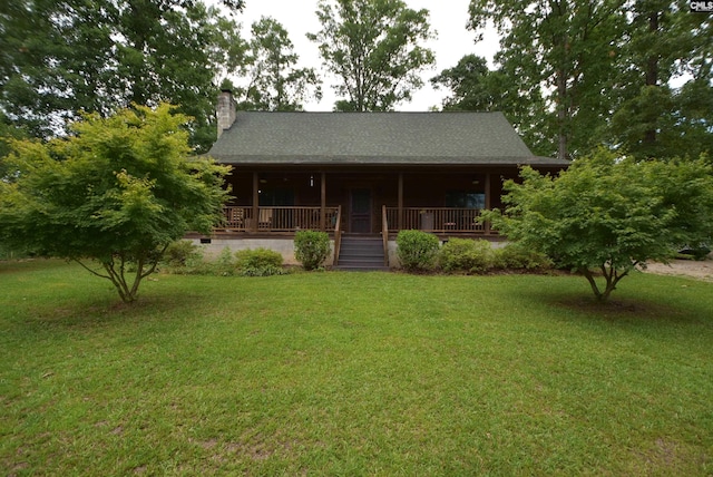 log cabin featuring covered porch and a front lawn