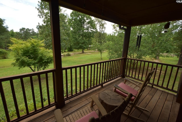 wooden deck featuring a lawn