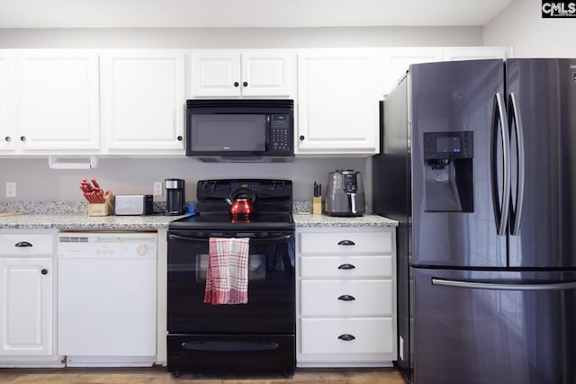 kitchen featuring black appliances, light stone countertops, white cabinetry, and wood-type flooring